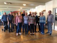 en gruppe ældre mennesker har stillet op til gruppefoto i deres beboerlokale i Hjallese, syd for Odense